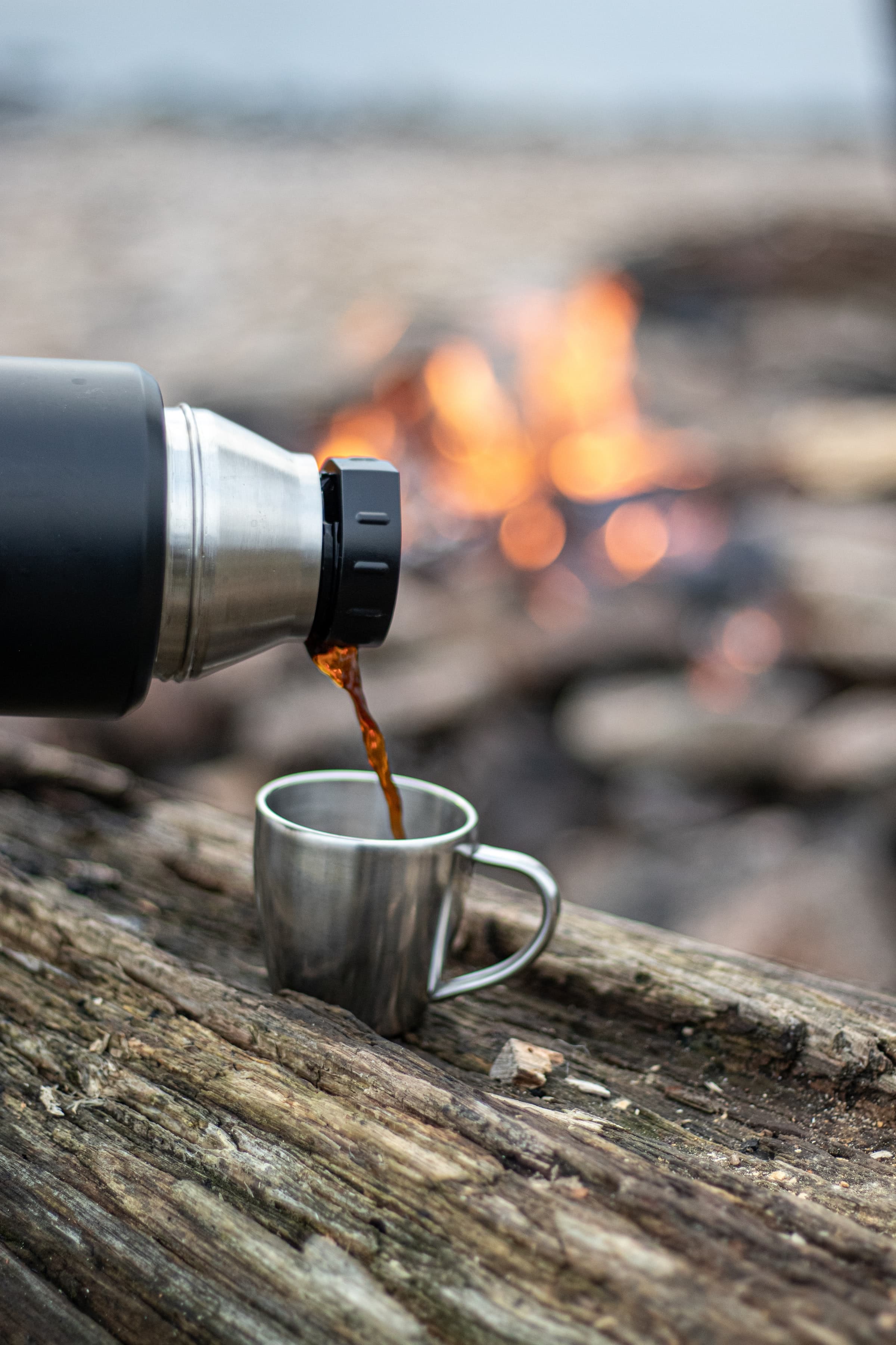 A silver and black coffee mug on a brown wooden table